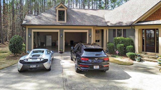 exterior space with a garage, concrete driveway, and a shingled roof