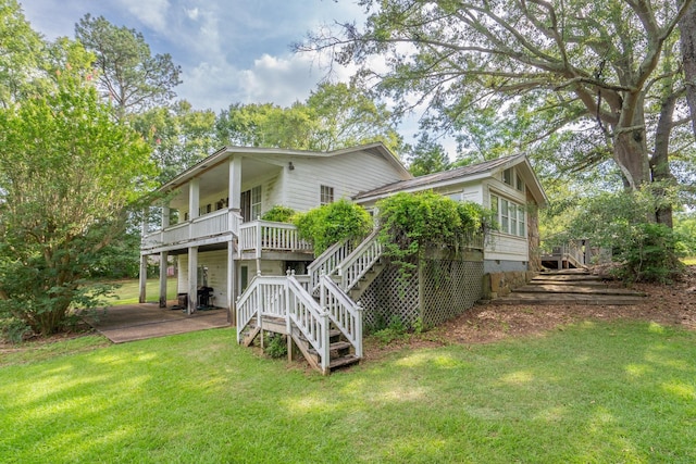 back of property featuring a wooden deck and a lawn