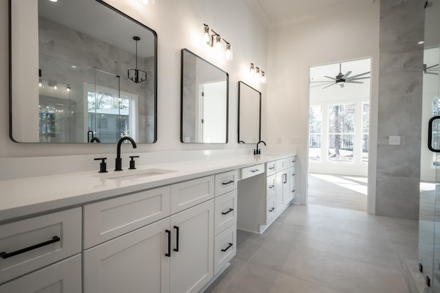 full bathroom featuring double vanity, a shower stall, a ceiling fan, and a sink