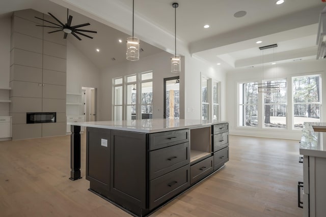 kitchen featuring open floor plan, ceiling fan, light wood finished floors, and light countertops