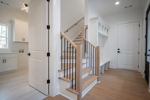 staircase with baseboards, visible vents, wood finished floors, and recessed lighting