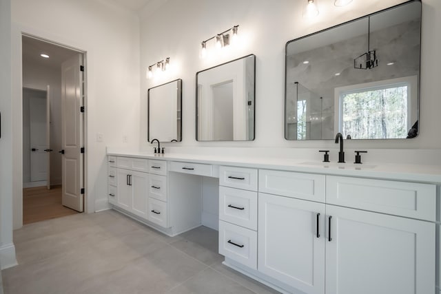 bathroom with double vanity, a stall shower, a sink, and tile patterned floors