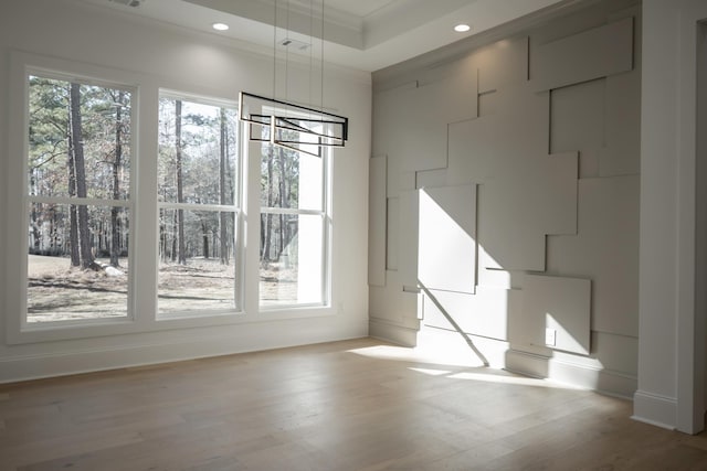 interior space with crown molding, light wood finished floors, recessed lighting, a raised ceiling, and visible vents