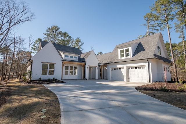 modern farmhouse style home with concrete driveway, brick siding, an attached garage, and roof with shingles