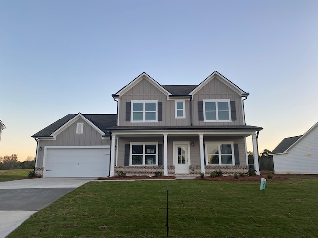 craftsman inspired home with a garage, a yard, and covered porch