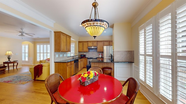 kitchen with stainless steel appliances, light hardwood / wood-style floors, sink, and backsplash