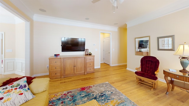 living room featuring ornamental molding, ceiling fan, and light hardwood / wood-style flooring