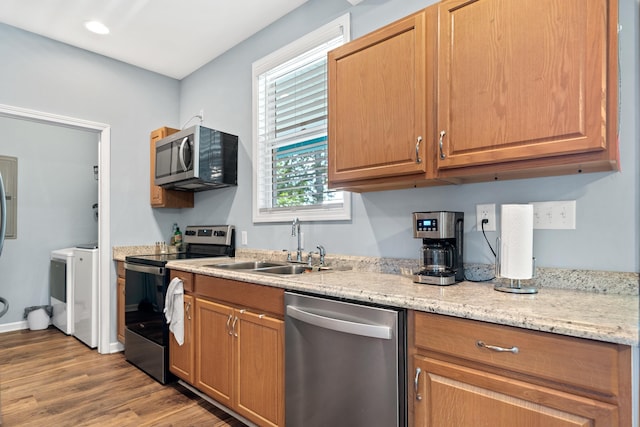 138B Little River Run, Eatonton, GA 31024 - kitchen with appliances with stainless steel finishes, wood finished floors, washer / dryer, light stone counters, and recessed lighting