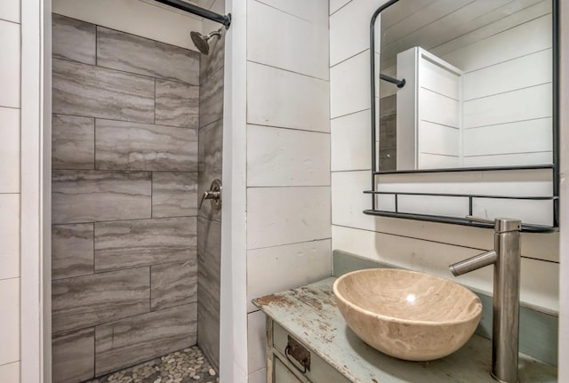 bathroom featuring tiled shower and vanity