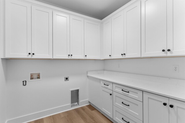 1731 Osprey Poynte, Greensboro, GA 30642 - laundry room featuring light wood finished floors, electric dryer hookup, visible vents, cabinet space, and hookup for a washing machine