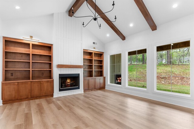 1731 Osprey Poynte, Greensboro, GA 30642 - unfurnished living room featuring a notable chandelier, high vaulted ceiling, wood finished floors, a large fireplace, and beamed ceiling