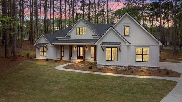 1731 Osprey Poynte, Greensboro, GA 30642 - modern inspired farmhouse with a standing seam roof, board and batten siding, a lawn, a shingled roof, and a porch