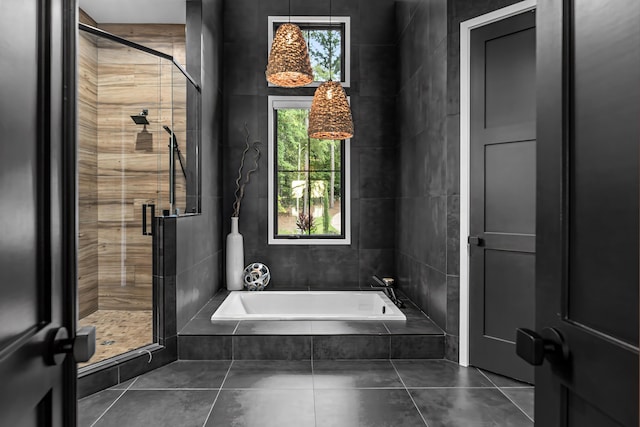 bathroom featuring a stall shower, tile patterned flooring, and a bath