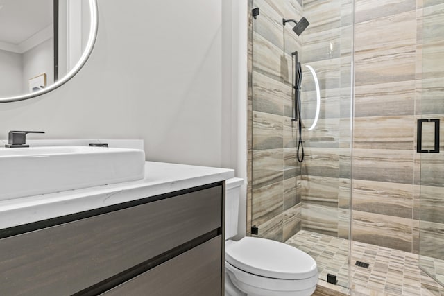 bathroom featuring toilet, a shower stall, crown molding, and vanity