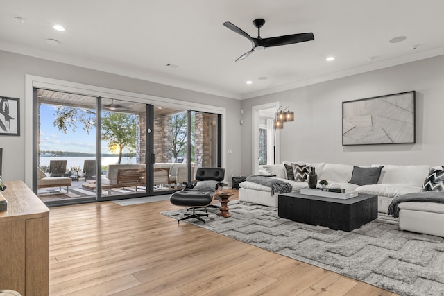 living room featuring crown molding, recessed lighting, a water view, light wood-style flooring, and ceiling fan