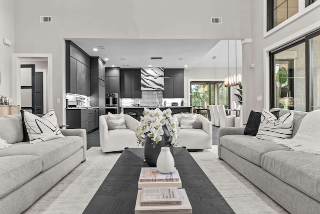 living room with recessed lighting, visible vents, and a towering ceiling