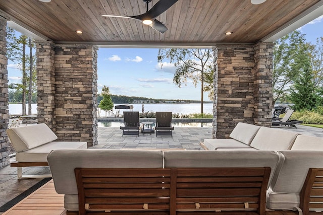 view of patio / terrace featuring a ceiling fan, a water view, and outdoor lounge area