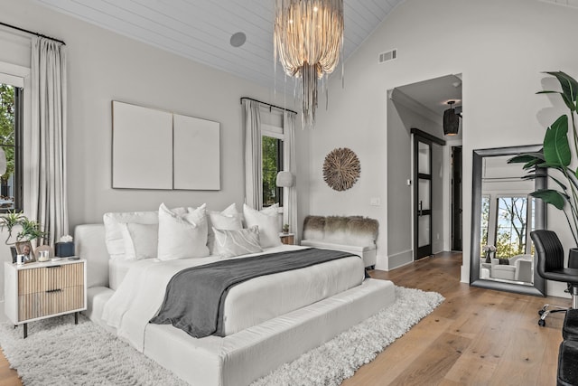 bedroom featuring a notable chandelier, visible vents, light wood-style flooring, high vaulted ceiling, and wooden ceiling