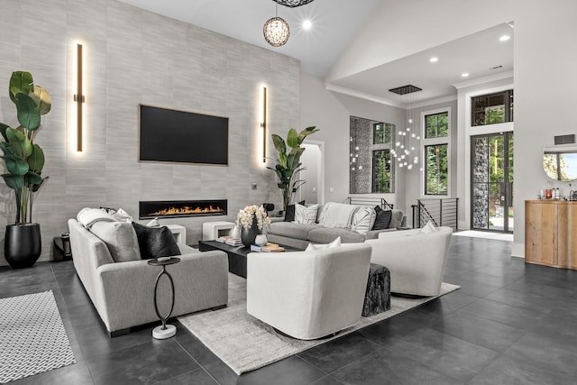 living area featuring recessed lighting, high vaulted ceiling, a notable chandelier, and a tile fireplace