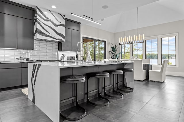 kitchen with light countertops, an island with sink, and modern cabinets