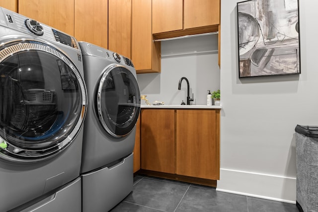 laundry area with washer and dryer, cabinet space, a sink, and dark tile patterned floors