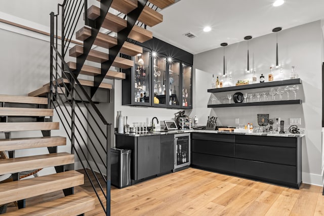 bar with wine cooler, visible vents, stairway, wet bar, and pendant lighting