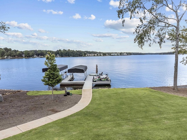 view of dock featuring a water view and a yard