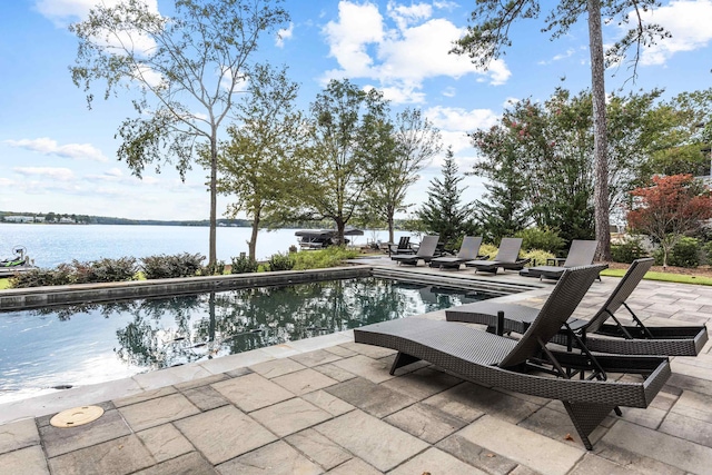 view of patio with a water view and an outdoor pool