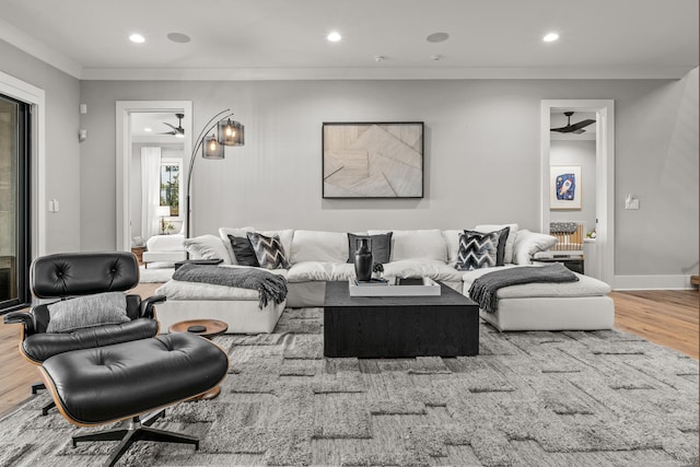 living room featuring baseboards, ceiling fan, wood finished floors, crown molding, and recessed lighting