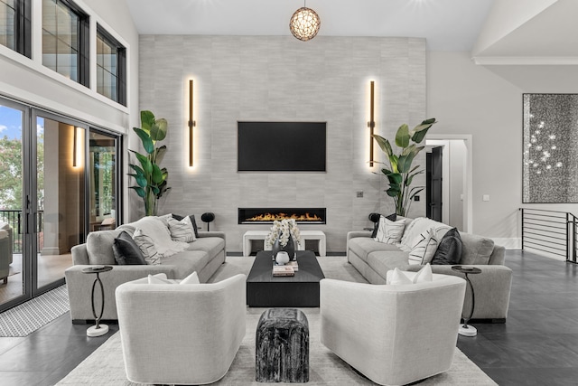 living area with a high ceiling and a tiled fireplace