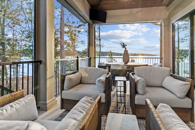 sunroom featuring a water view