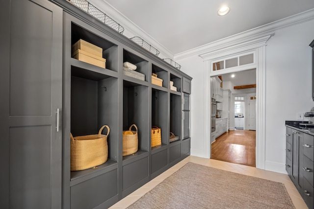 mudroom featuring ornamental molding and light tile patterned flooring