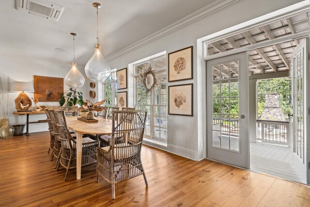 dining space featuring crown molding and light hardwood / wood-style floors