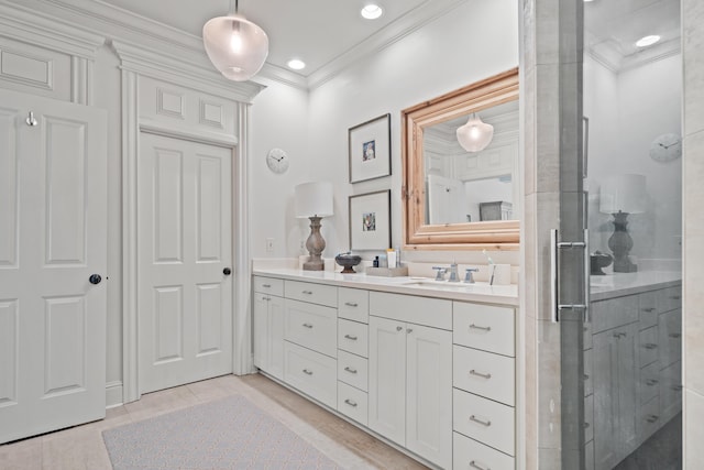 bathroom featuring tile patterned flooring, ornamental molding, a shower with door, and vanity