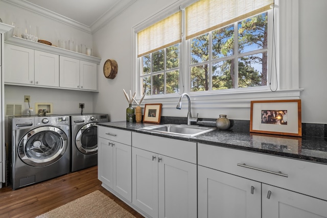 laundry area featuring sink, crown molding, dark wood-type flooring, cabinets, and independent washer and dryer