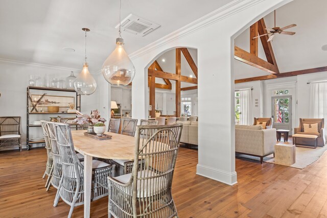 dining area with wood-type flooring, ornamental molding, ceiling fan, and high vaulted ceiling