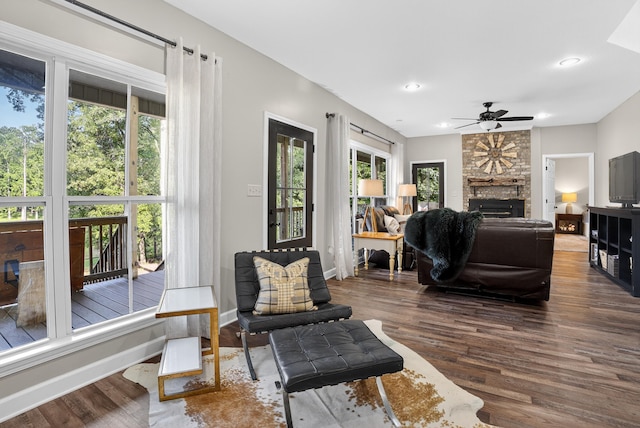 1005 Dennis St, Eatonton, GA 31024 - living area with dark wood-style flooring, a ceiling fan, a stone fireplace, and recessed lighting