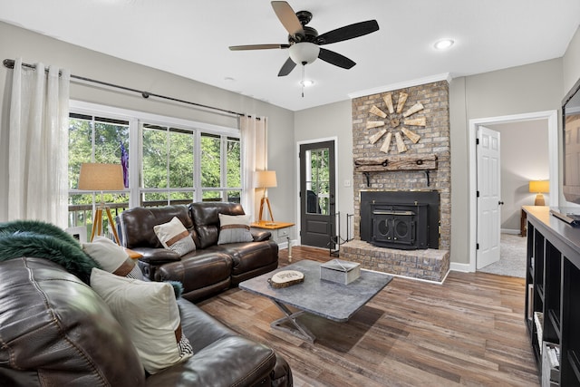 1005 Dennis St, Eatonton, GA 31024 - living room featuring wood finished floors, ceiling fan, recessed lighting, and a wood stove
