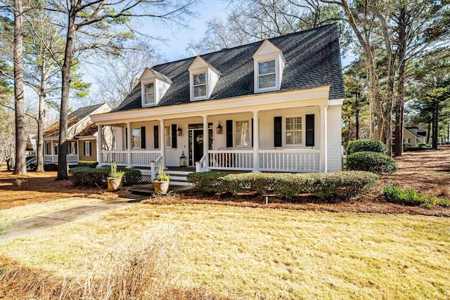 new england style home featuring a porch and a front lawn