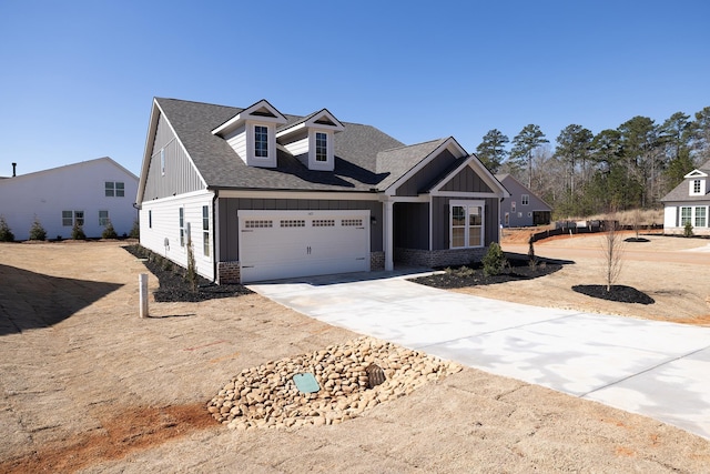 view of front of property featuring board and batten siding, concrete driveway, a shingled roof, and a garage