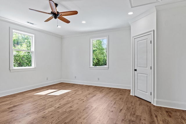 unfurnished room with hardwood / wood-style floors, ornamental molding, and a wealth of natural light