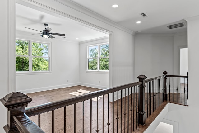 hall with crown molding, plenty of natural light, and hardwood / wood-style flooring