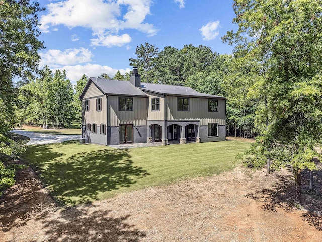 rear view of property featuring a lawn