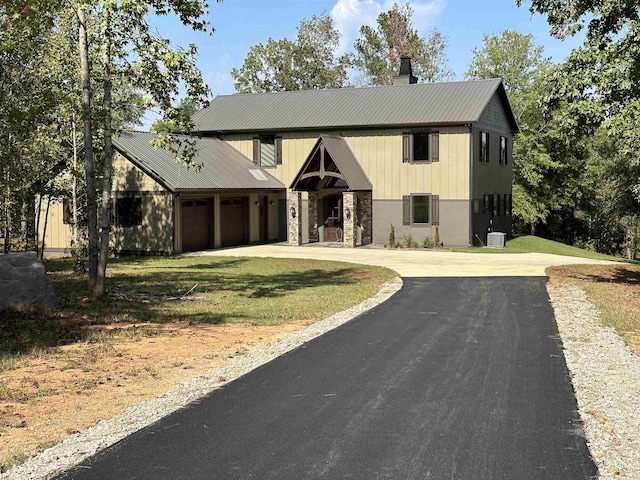 view of front of property with a garage and central air condition unit