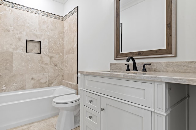 full bathroom featuring tiled shower / bath, vanity, toilet, and tile patterned flooring