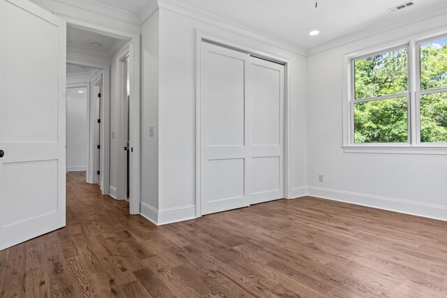 unfurnished bedroom with hardwood / wood-style floors and a closet