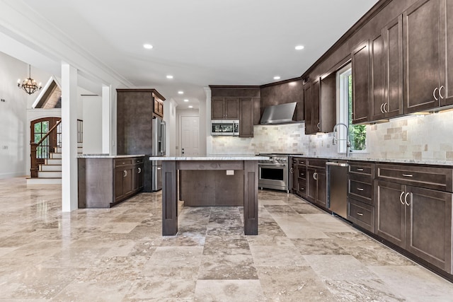 kitchen featuring wall chimney exhaust hood, dark brown cabinetry, light stone counters, a center island, and premium appliances