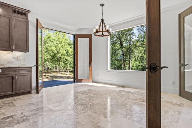 unfurnished dining area featuring a chandelier