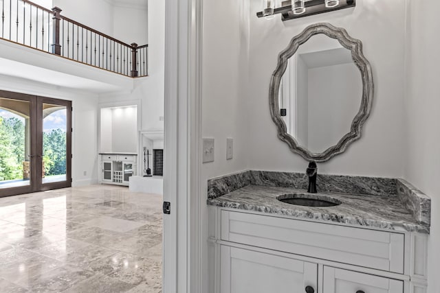 bathroom with french doors, vanity, and a high ceiling