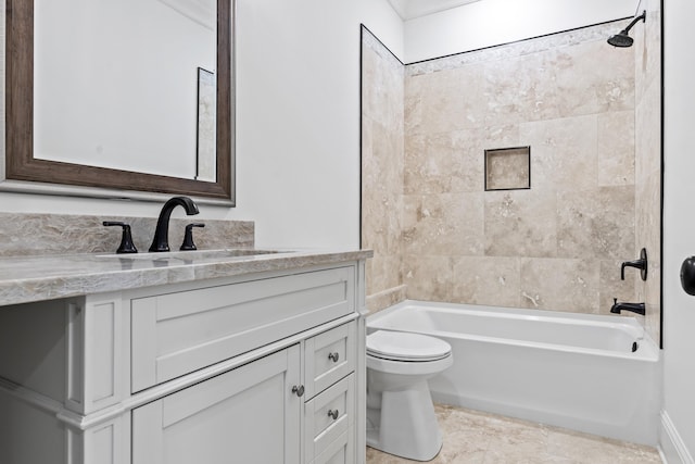 full bathroom featuring tiled shower / bath, vanity, and toilet